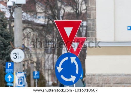 Give way and roundabout traffic signs in a small busy town.