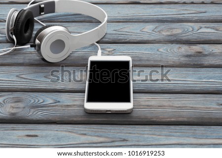 smartphone, headphones on a wooden background. listening to music. audio. music lover.