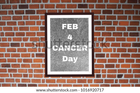 Calendar The letter Feb 4 , world of Cancer day on gray picture frame on brick wall background