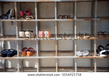 Shoes rack, shoes shelf made from steel, old and rusty outdoor shoes rack in front of temple in Bagan, Myanmar. People must take off their shoes before visit inside temples. Royalty-Free Stock Photo #1016921758