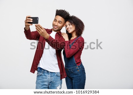 Young attractive African American Couple Pose For selfie pose with smart phone Royalty-Free Stock Photo #1016929384