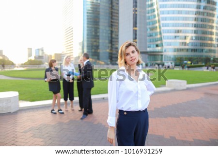 Businesswoman looking at camera with close up face in   and speaking employees background. Concept of female boss and successful team work. People in business wear style discussing best decisio
