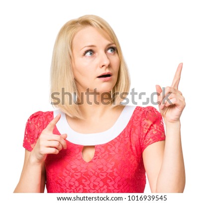 Portrait of woman with beautiful face, isolated on white background. Young cute girl showing different emotions - surprise, pointing fingers something. Female wearing a pink dress.