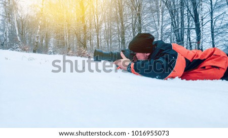 Photographer photographs animals while lying in the snow