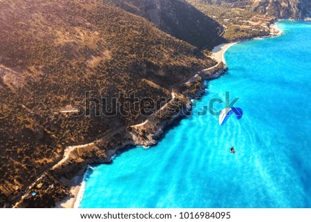 Paragliding flight over the sea coast of the Mediterranean Sea. Blue parachute against the blue sea. Turkey. Oludeniz. Aerial photography. Travel and sport concept.