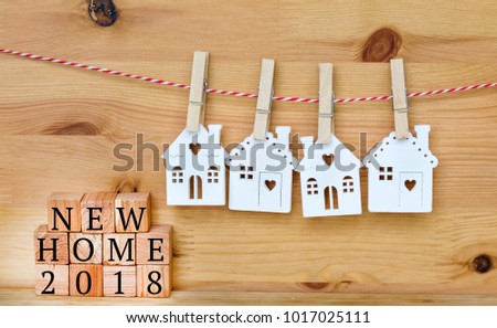 New Home for 2018 Concept with Hanging Small White Houses on a Wooden Background