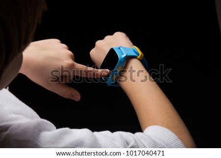 Little boy using his smartwatch. Wearable children tracking gadget with touch screen and voice service, electronic wristband for children