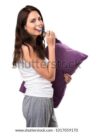 Beautiful young girl with a pillow and with a toothbrush
