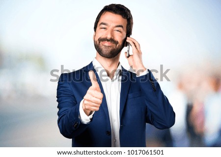 Handsome man talking to mobile on unfocused background