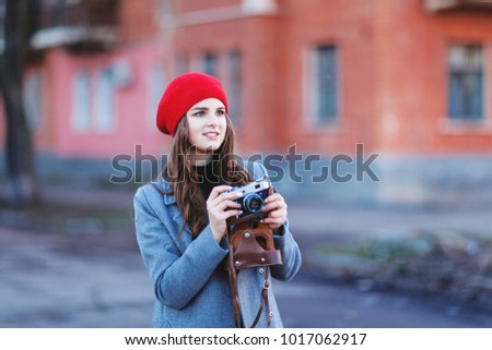 Beautiful hipster girl shooting with retro camera