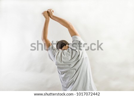 A young person having his arms up as he is holding/hanging.For concept use.