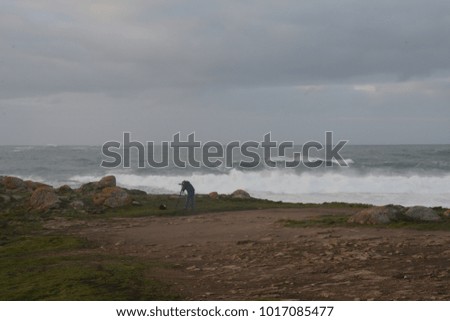 people photographing storm waves at sunset
