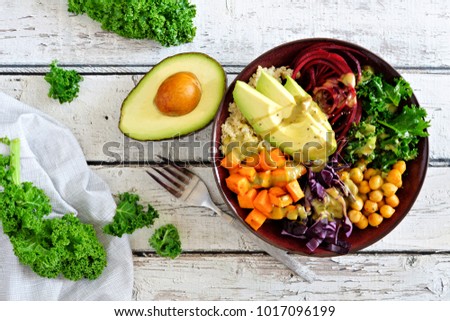 Buddha bowl with quinoa, avocado, chickpeas, vegetables on a white wood background, Healthy food concept. Top view.