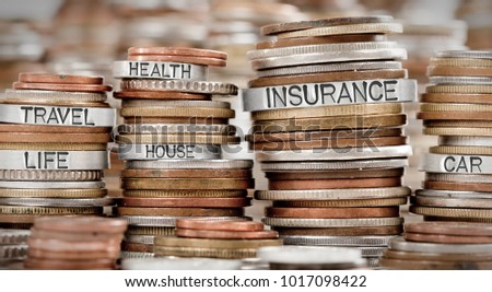 Photo of various stacks and rows of coins with INSURANCE concept related words imprinted on metal surface