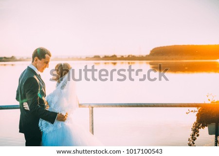 St. Valentine's Day. Bride and groom, love, friendship, relationship, silhouette picture bride embrace on the bridge cloudy sky emotions happiness new family