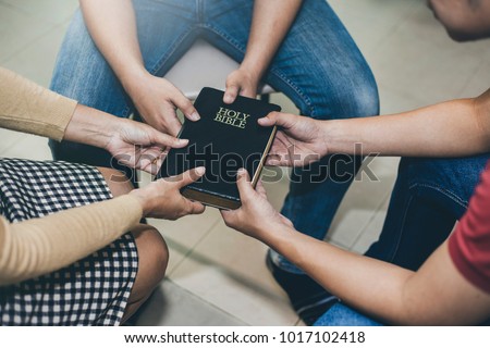 Three people holding bible and pray together, christian group