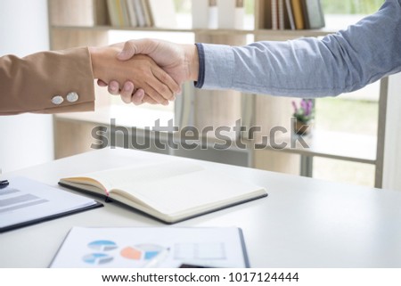 Two businesspeople shaking hands during a meeting to sign agreement and become a business partner, enterprises, companies, confident, success dealing, contract between their firms.