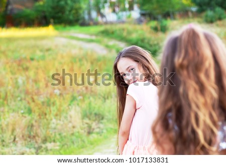 Beautiful young girl with long brunette hair, looking to camera at summer day. Having fun of joyful kid. Place for text