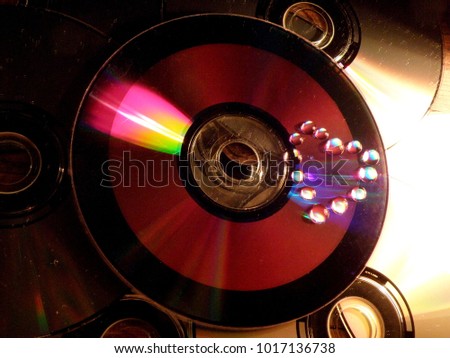 Iridescent drops in the shape of a heart on a disk
