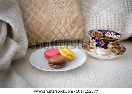 Macaroons and tea cup in cozy living room 