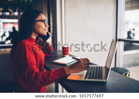 Professional African american copywriter talking about new project on mobile earning money online.Attractive dark skinned manager in stylish spectacles checking banking account talking with operator Royalty-Free Stock Photo #1017177697