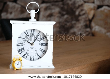 Simple yellow alarm clock and vintage wise table clock, big and small with the same function