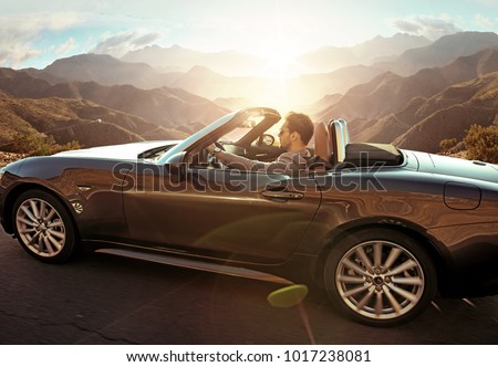 
 Young attractive couple posing in a convertible car, by the sea Royalty-Free Stock Photo #1017238081