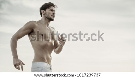 
Fitness athlete man posing on clear sky background.