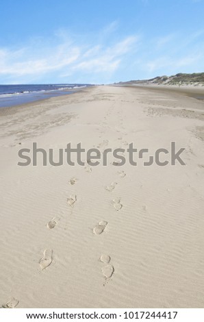 Two footprints in the sand of the beach of Egmond aan Zee .
