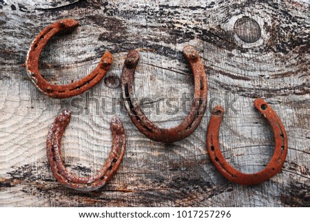 Four old rusty horseshoes on wooden ground. Horseshoe as lucky charm

