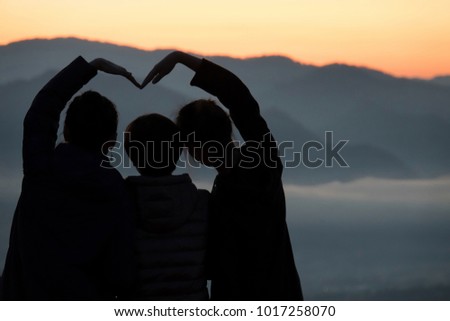 Love mom,Family making heart shape over mist sea,Silhouette tone