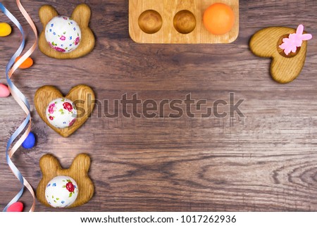 Happy Easter concept. Wooden stands of eggs with spring's eggs with flowers picture on wooden background with colorful ribbons