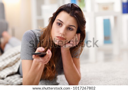 Picture of beautiful young woman relaxing at home watching tv