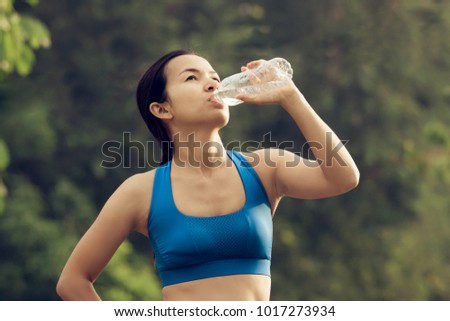 Woman drinking water after exercise