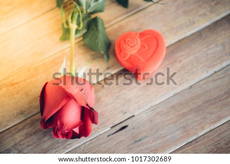 Red rose flower nature beautiful flowers from garden and ring red box heart shape design for valentines on wooden floor with copy space in Valentine's Day, Wedding or Romantic Love Valentine concept