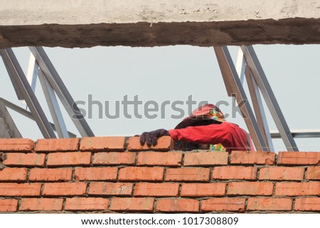 construction workers are building a brick red brick wall

