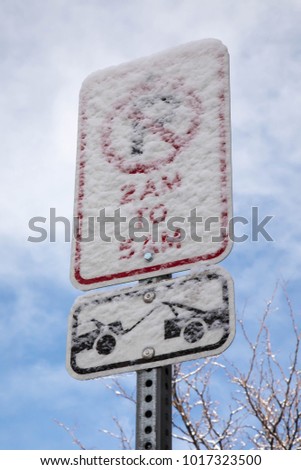 Snow covered no parking sign