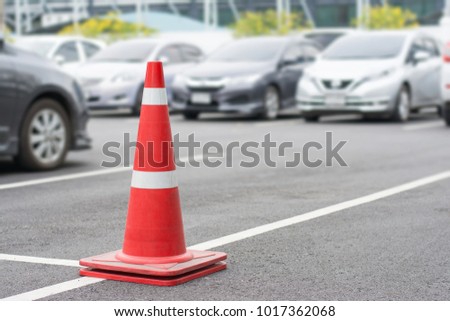 Red traffic cones  at parking area in daytime.