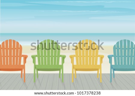 Four colorful wooden Adirondack chairs in a row on a wooden deck at the beach. Beautiful and relaxing sky with wispy clouds.
