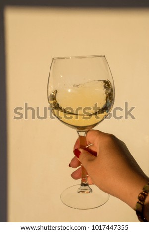 Tasting of glass of cold white wine served on outdoor terrace with beautiful romantic  sea view, woman hand