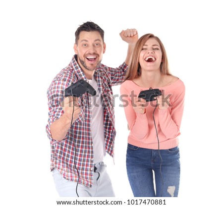 Happy couple with video game controllers on white background