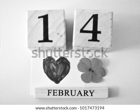 The white/black picture of wood calendar valentine's day with a flower and heart painting on white background