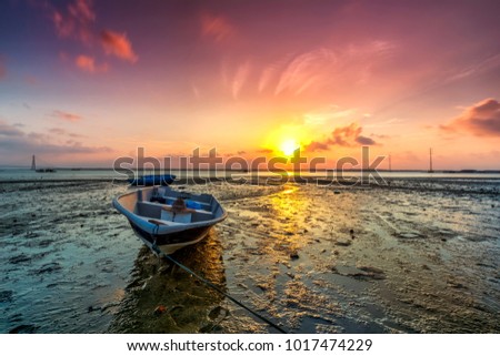 Long exposure picture of fishing boat with golden sunset as a background