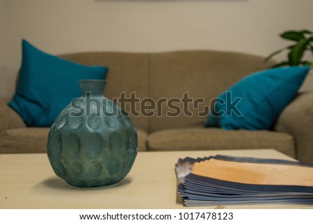 View of table top of an office waiting room. Image presents decorative on the foreground and a brown couch in the background