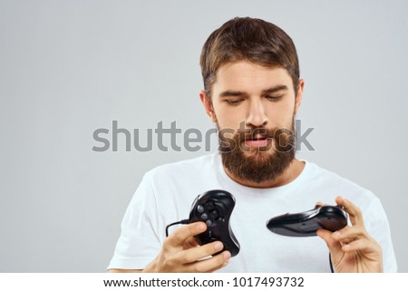  man looks at the joysticks on a light background                              