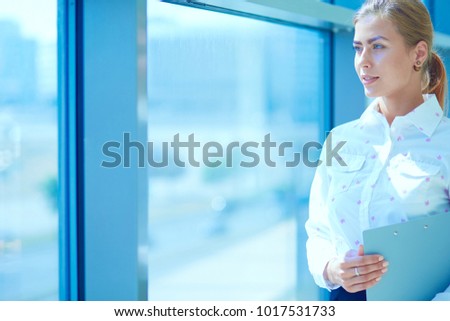 Business woman standing in foreground in office . Business woman