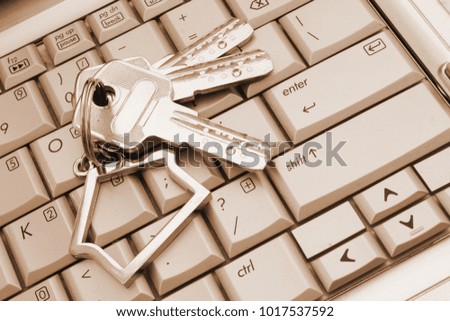 Real estate service concept with keys and house symbol on laptop keyboard