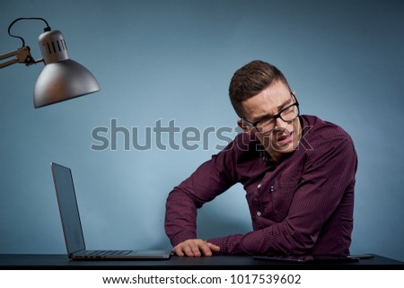 business man in the office sits at a table on a blue background                              