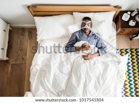 Man sleeping with an anti-snoring mask Royalty-Free Stock Photo #1017541804