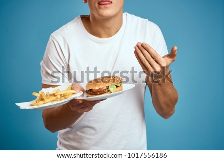  man holding plates with fast food on a blue background                              